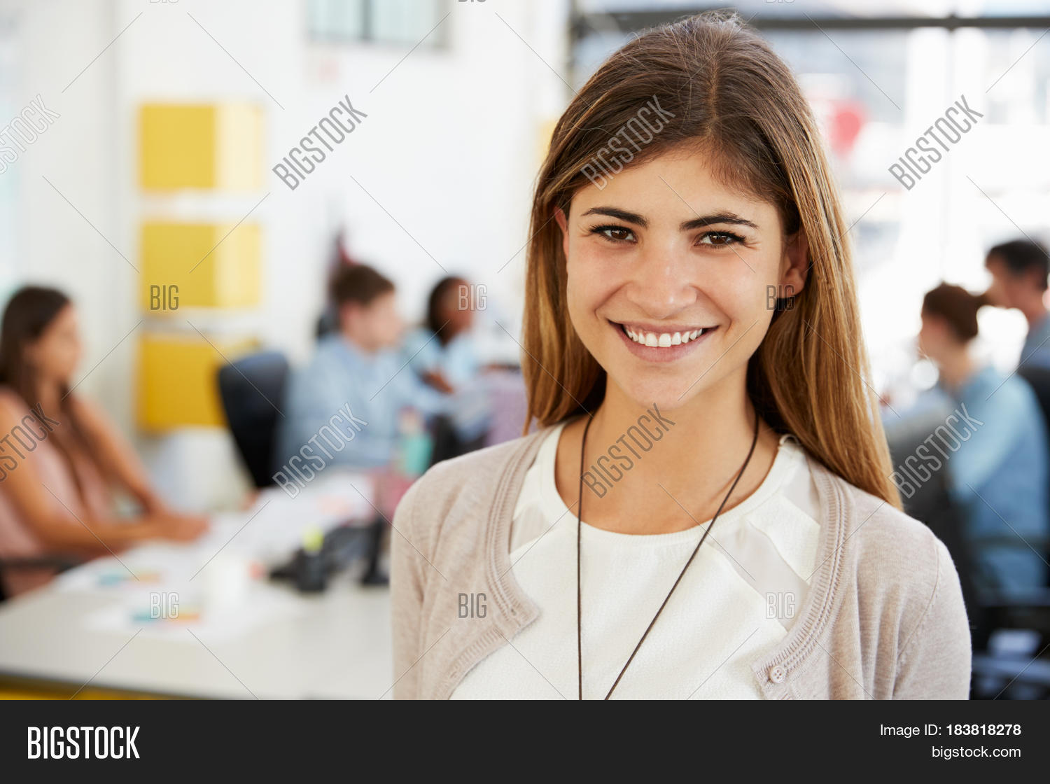 mid adult white woman smiles to camera in open plan office