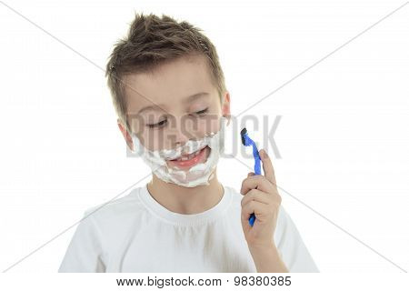 playful little young boy shaving face over white