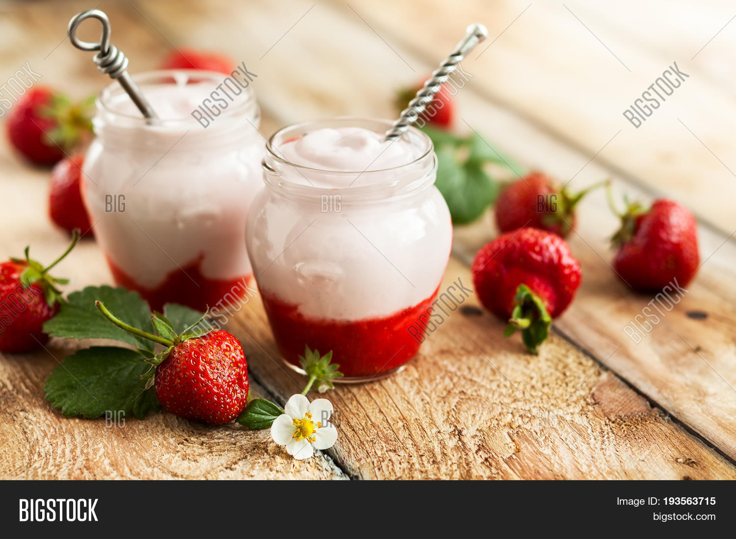 delicious strawberry yogurt in jars surrounded by fresh berries