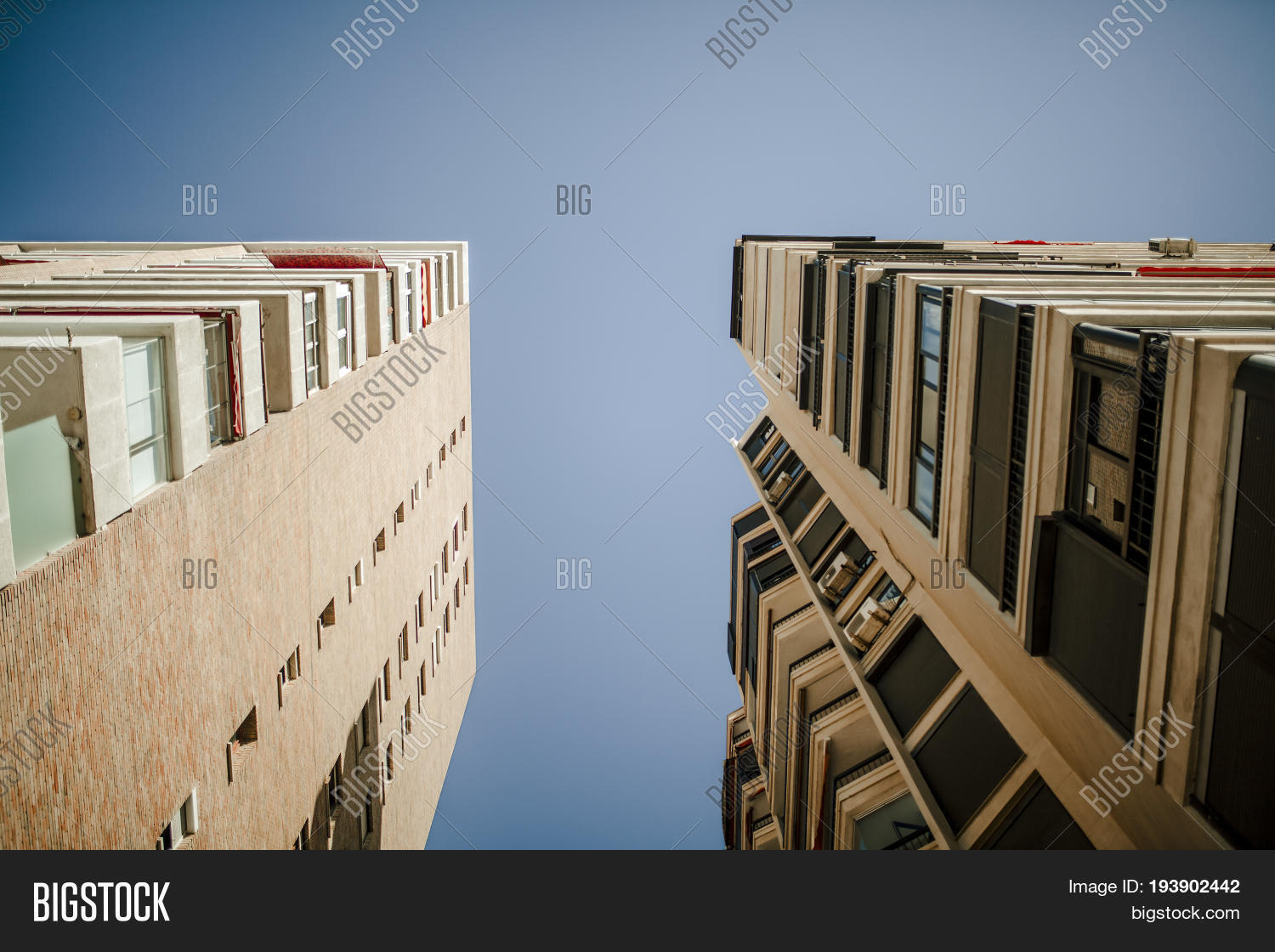 low angle view of generic apartment buildings, with blue sky in