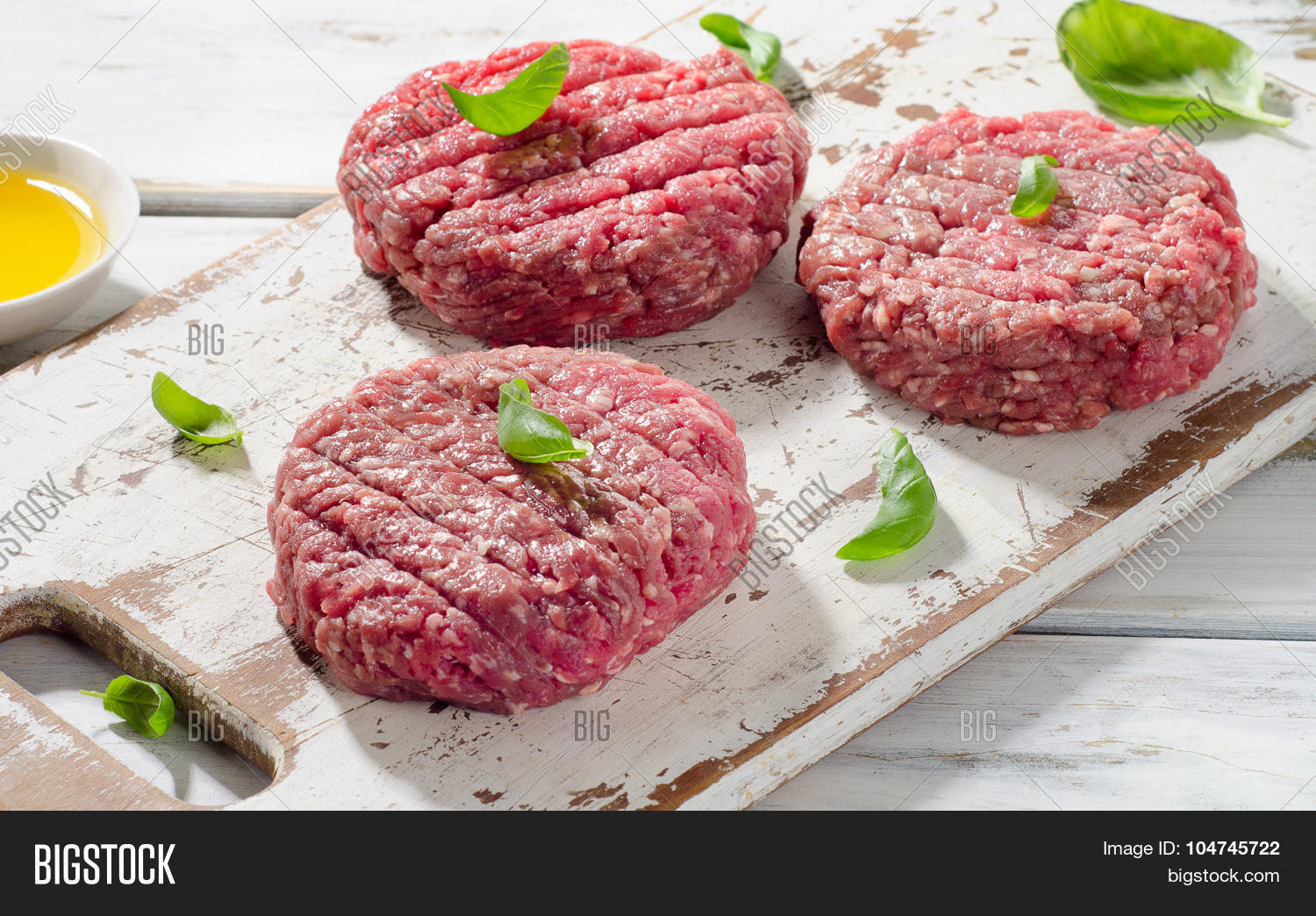 raw ground beef burger steak patties on a white wooden cutting