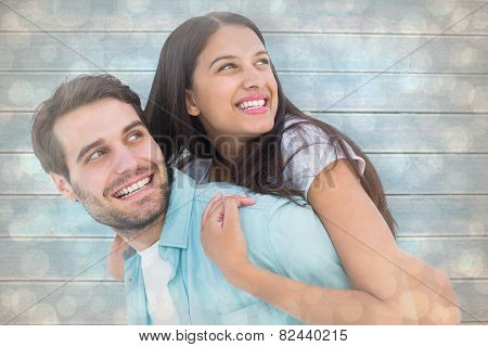 happy casual man giving pretty girlfriend piggy back against