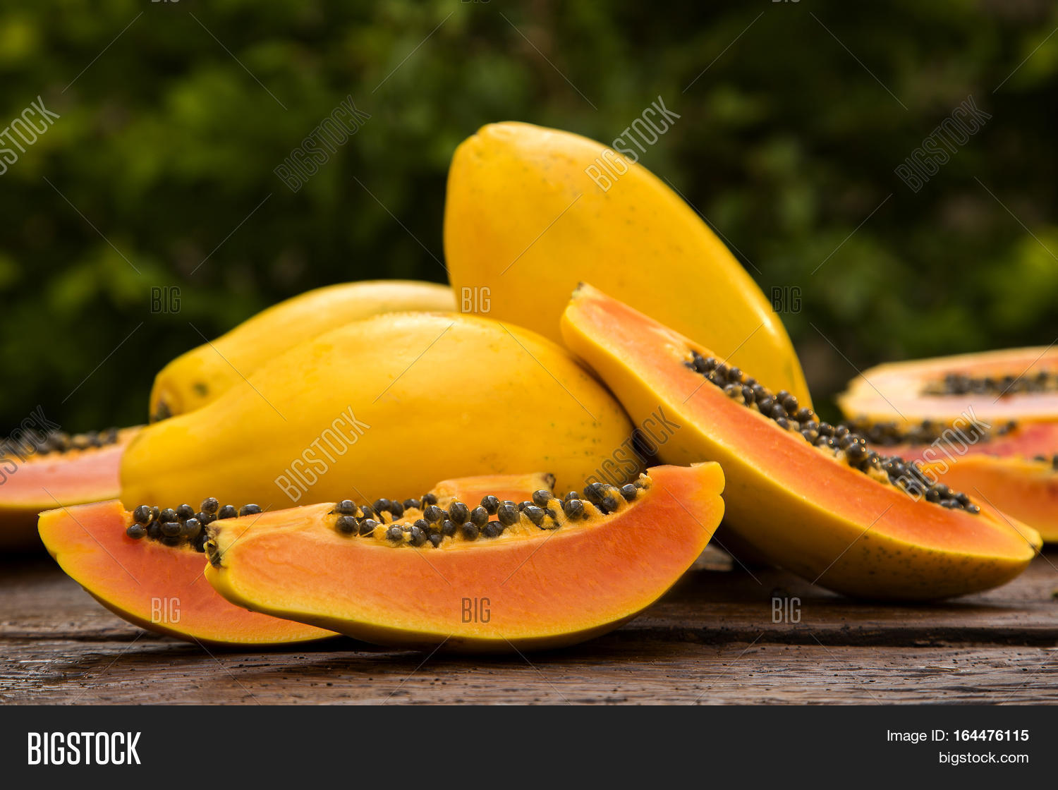 sliced fresh papaya on wooden background. fresh fruits.