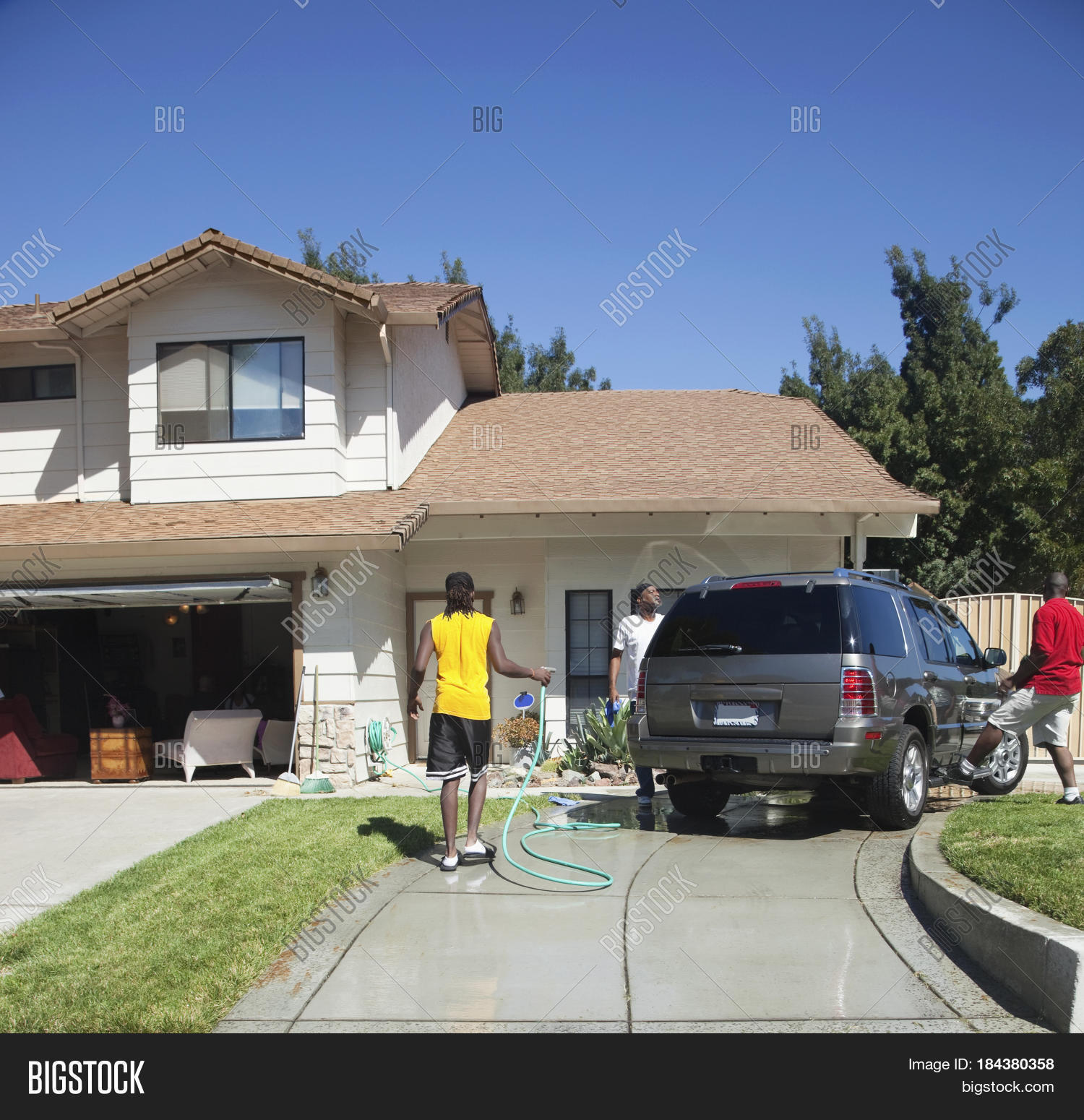 black family washing car in driveway
