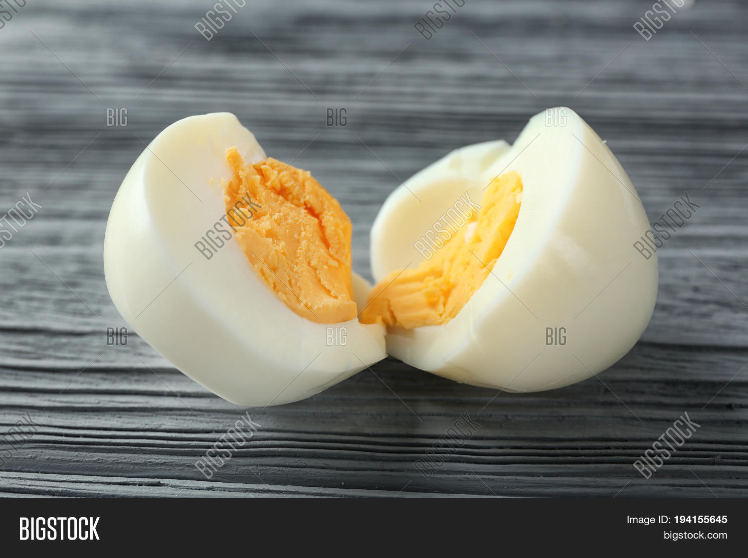 sliced hard boiled egg on wooden background. nutrition concept