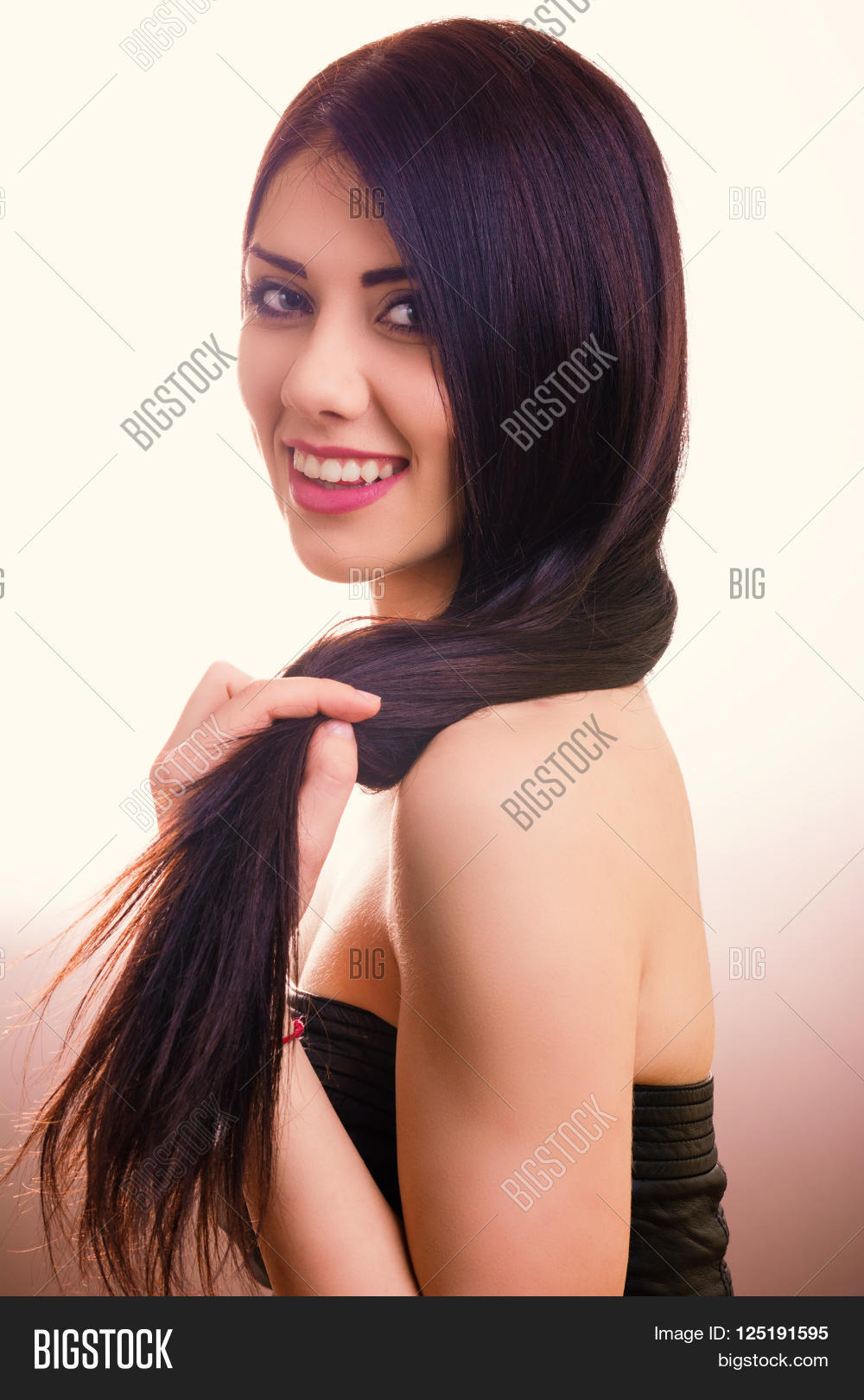 beautiful young woman with long straight hair posing in a studio