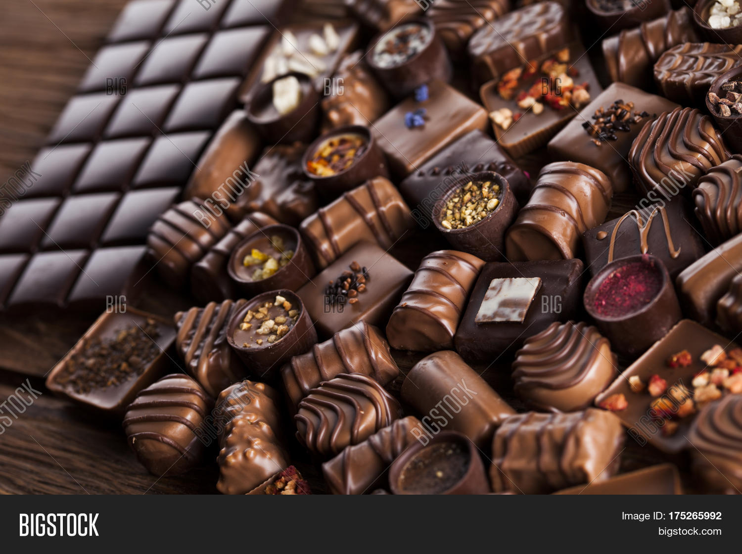 chocolate bars and pralines on wooden background