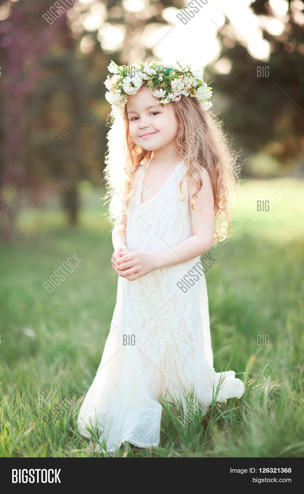 smiling baby girl 4-5 year old wearing wreath with flowers