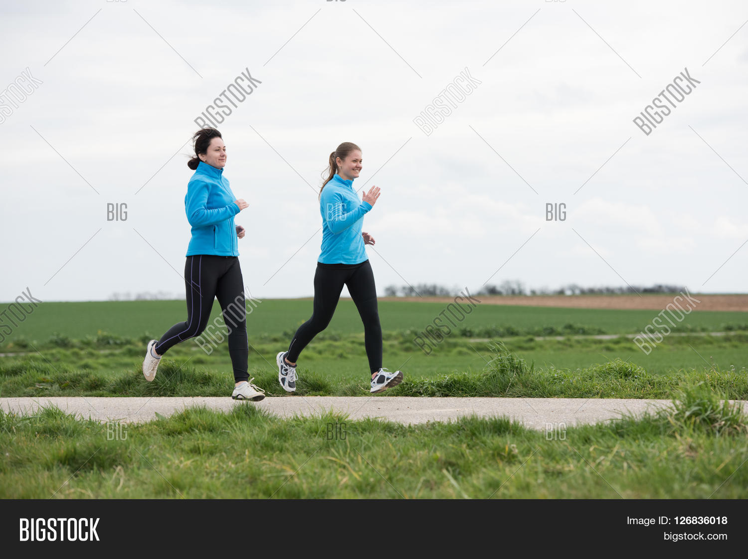 two women 40 and 20 years old jogging (running) outdoors