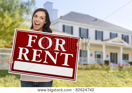 excited mixed race female holding for rent sign in front of