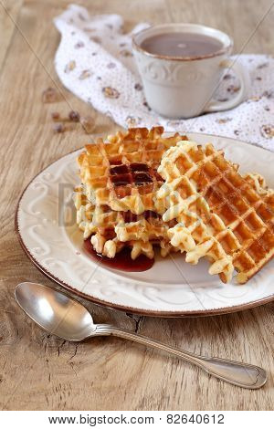 belgian waffles with syrup and a cup of cocoa