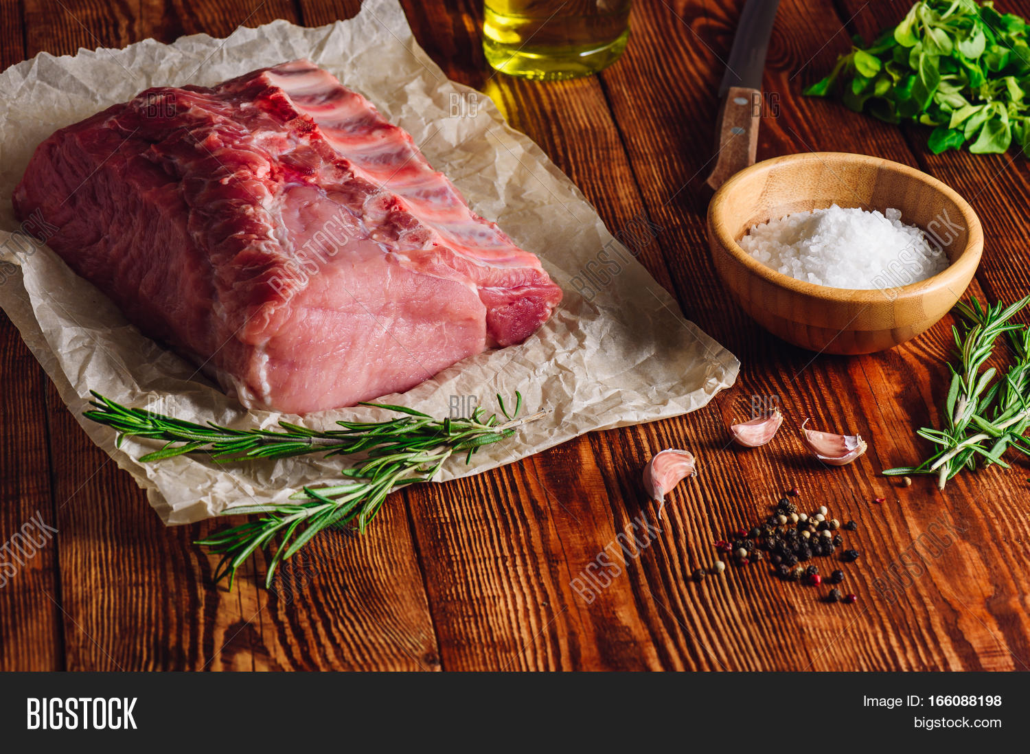raw pork loin with ribs and some ingredients for roasting