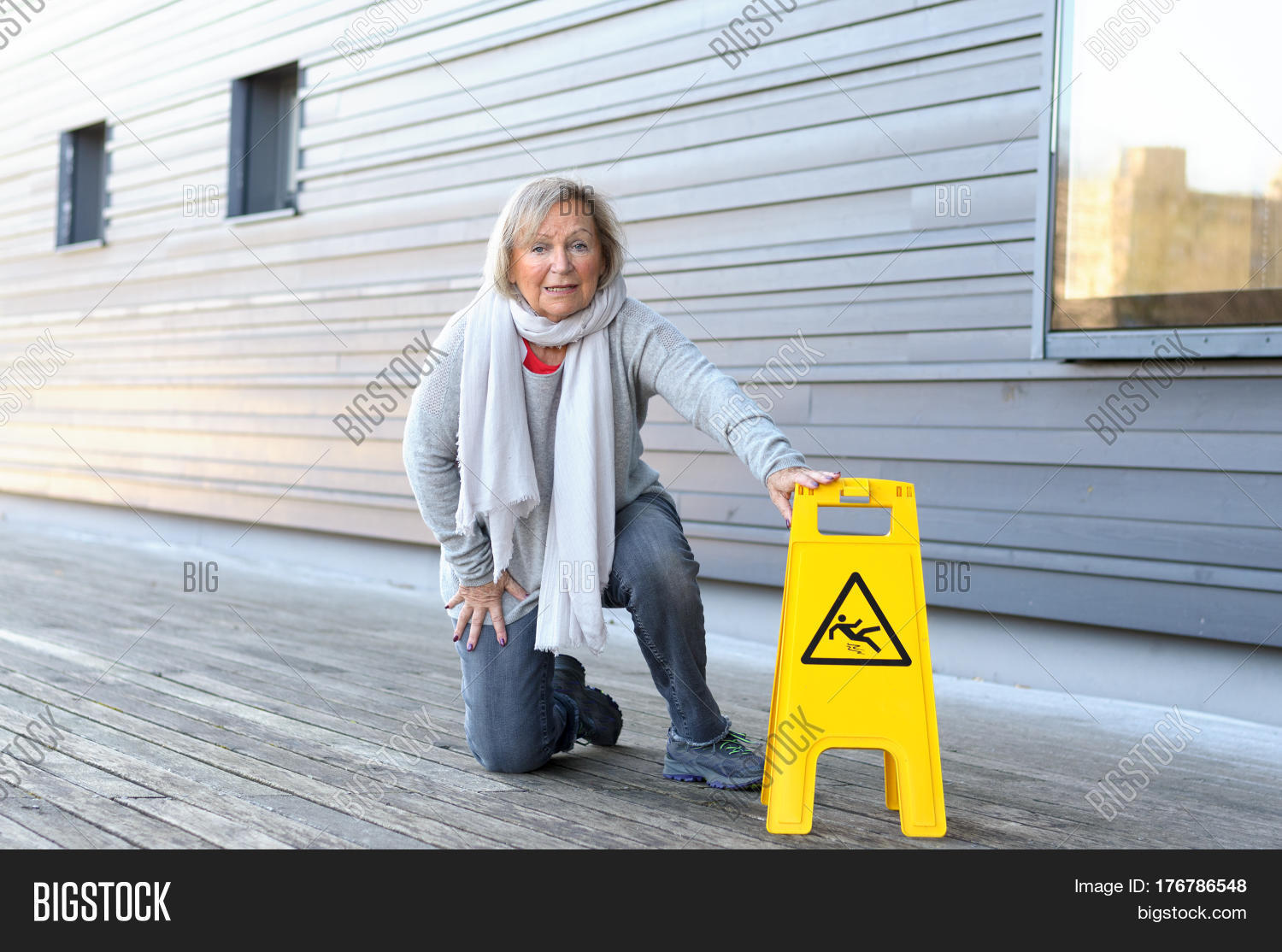 elderly woman crawling on her knees after slipping 库存照片和