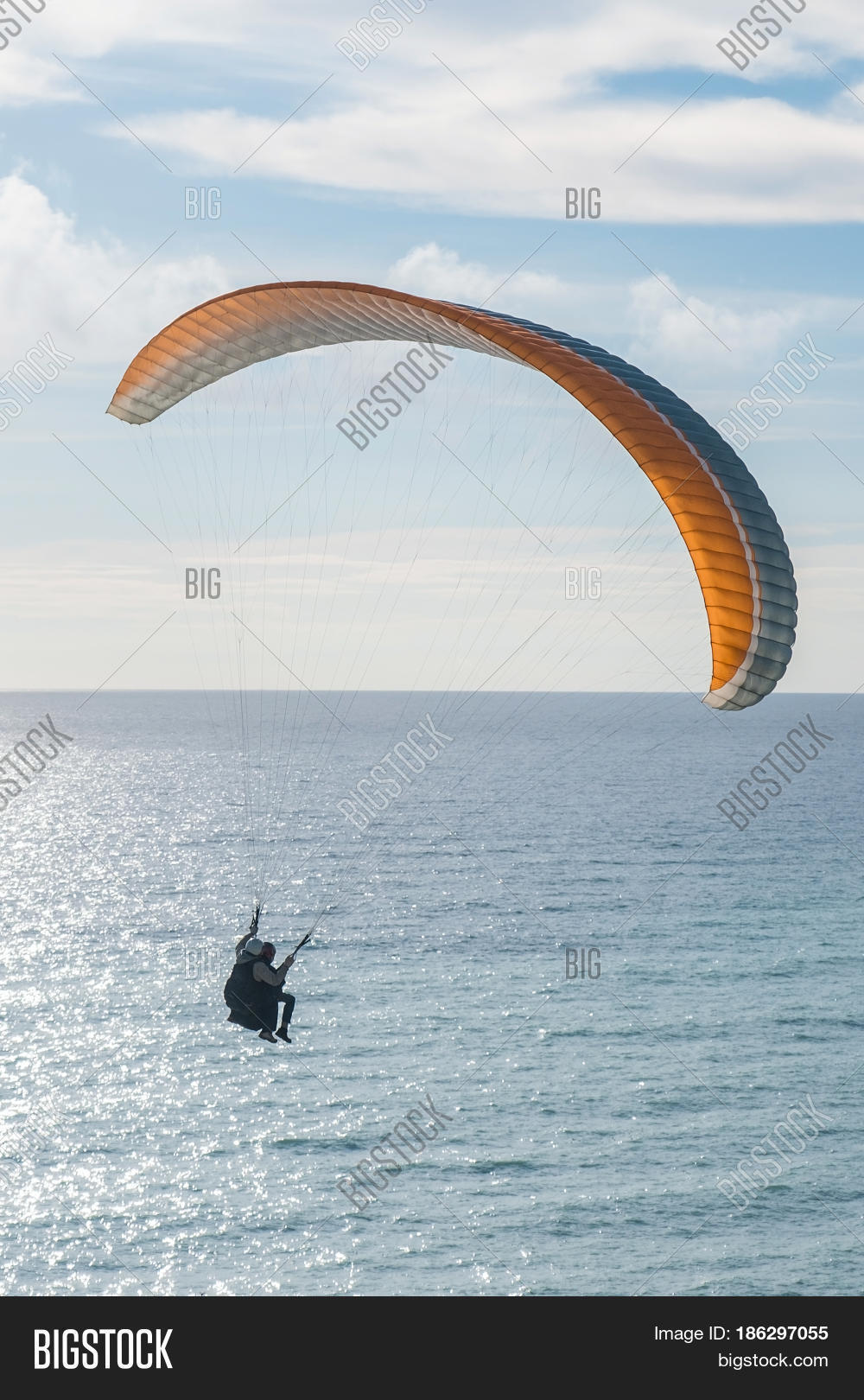 flying tandem paraglider over the sea, vertical shot.