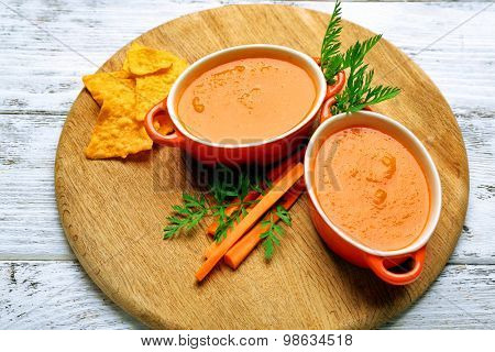 carrot cream-soup with chips on table close up