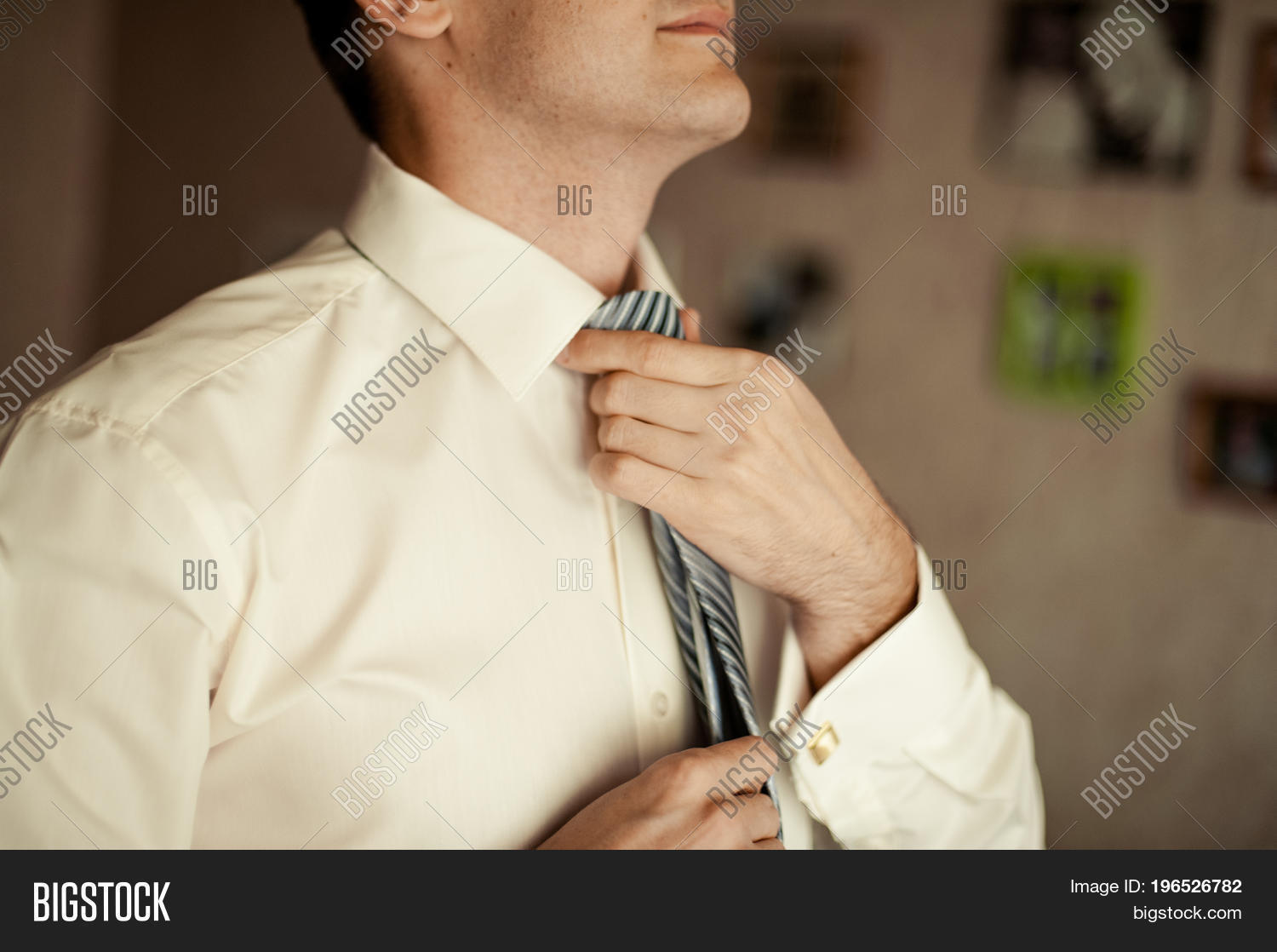 the groom in a suit corrects a tie. grooms accessories