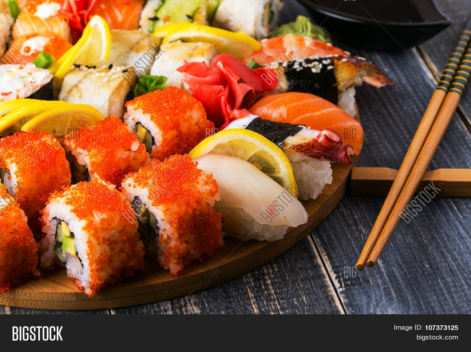 sushi set: sushi and sushi rolls on wooden plate selective focus