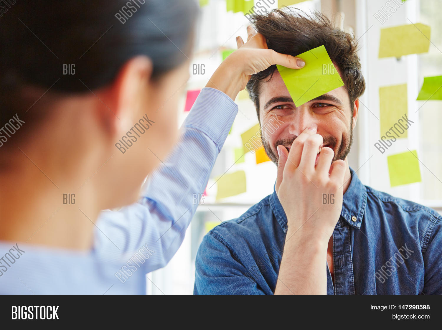 sticky note on mans forehead during team training game in work