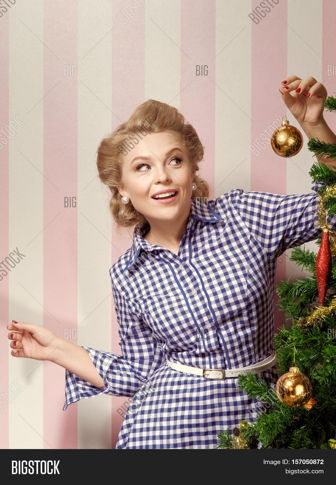 portrait of nice young woman hanging around christmas tree on x