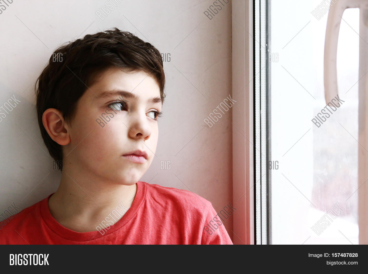 close up preteen boy portrait look at the window serious lonely