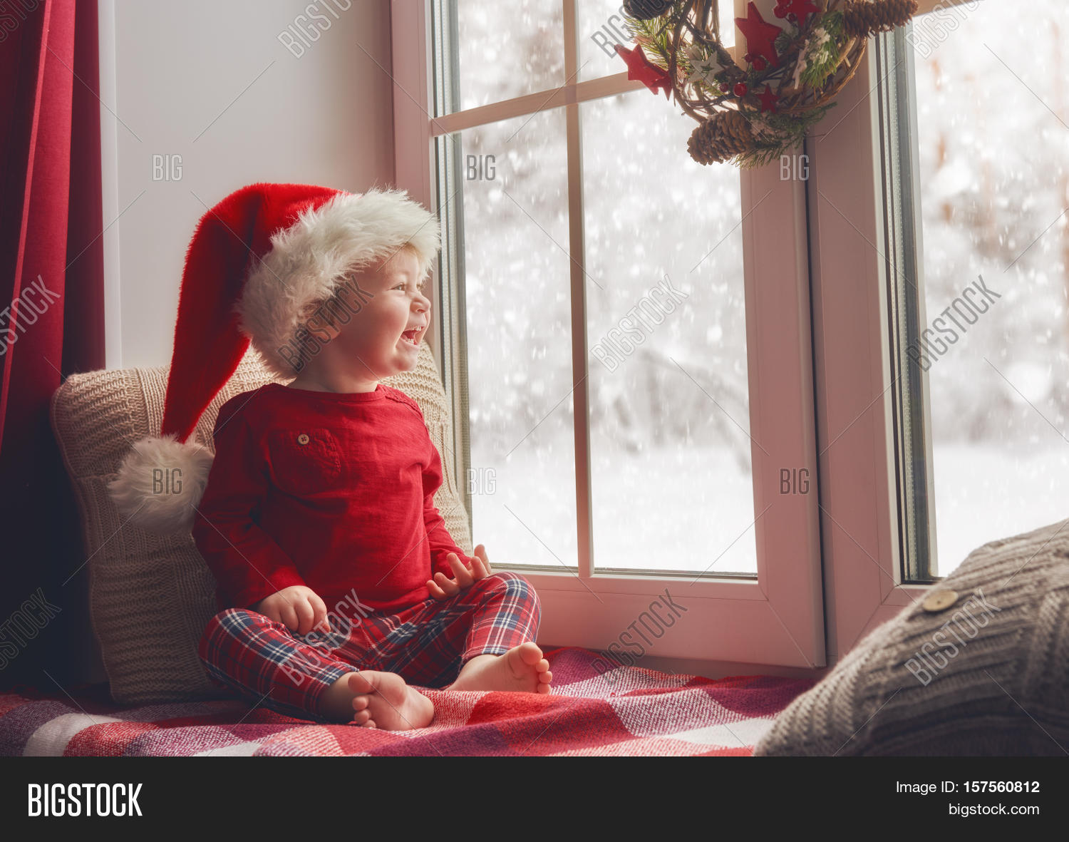 cute little baby girl sitting by the window and looking at te