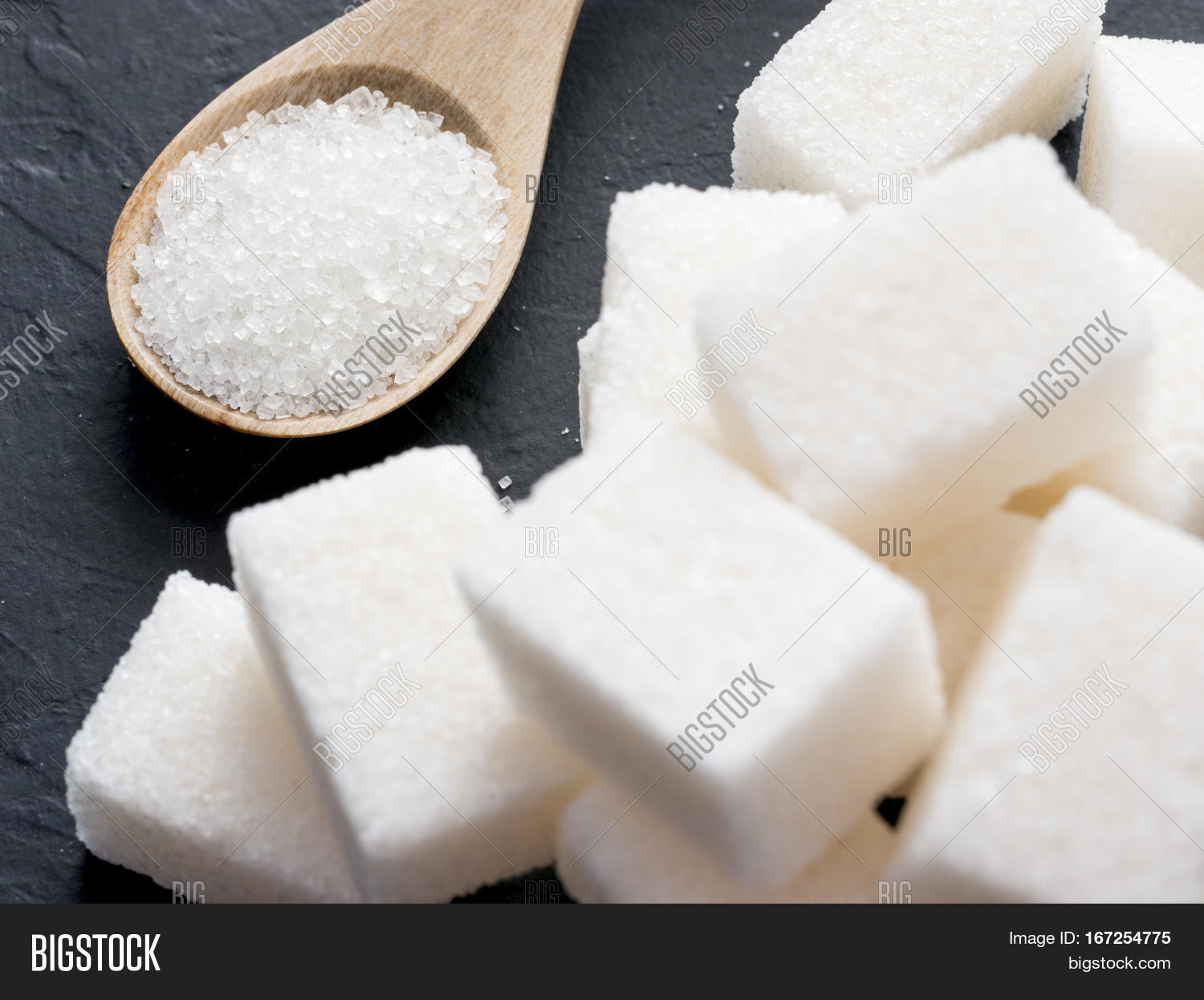 background of sugar cubes and sugar in spoon.
