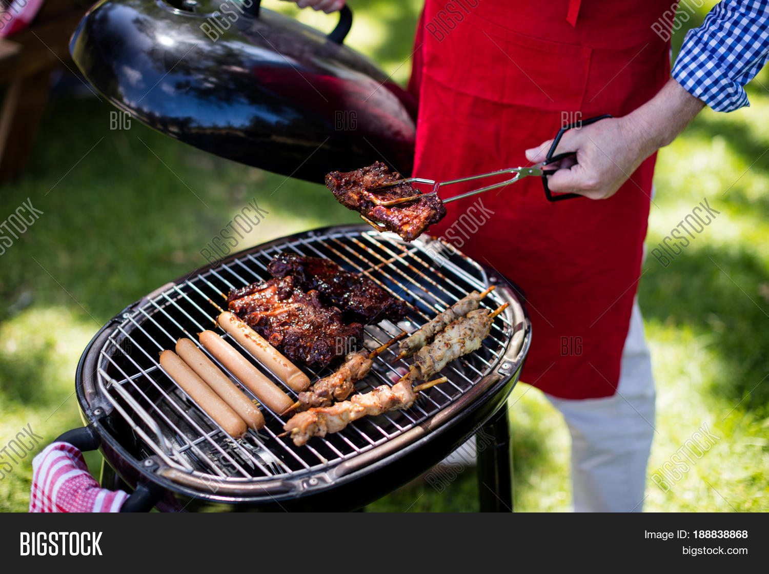 mid section of man barbequing in the park