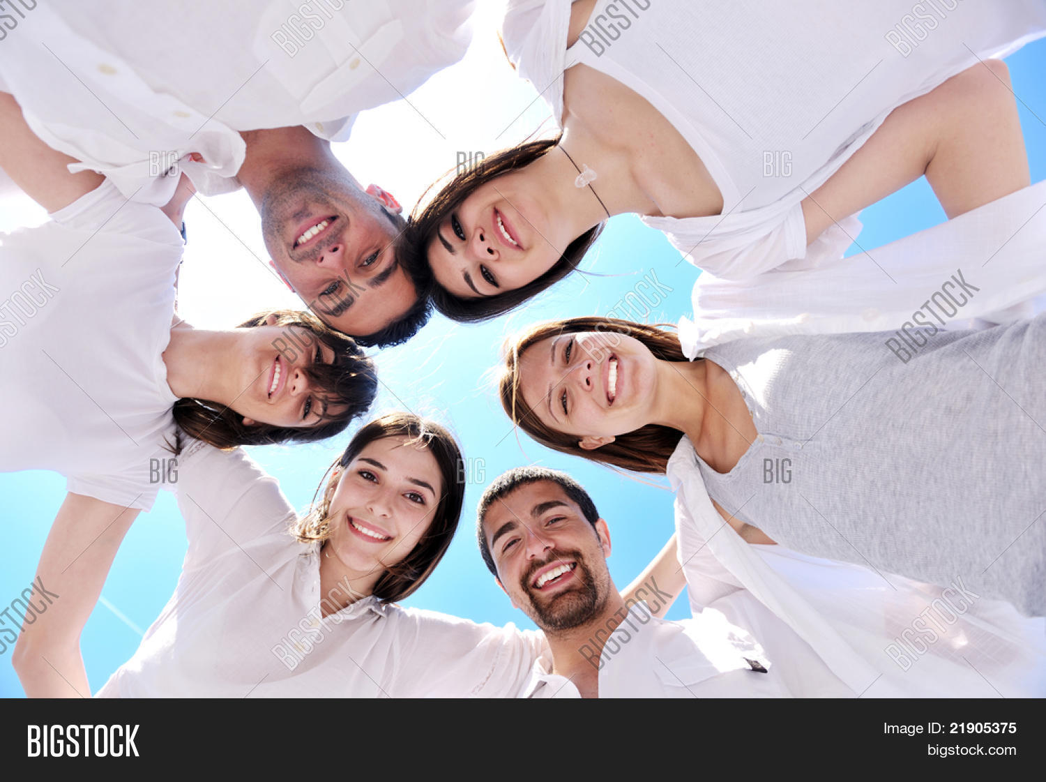 group of happy young people in circle at beach have fun and