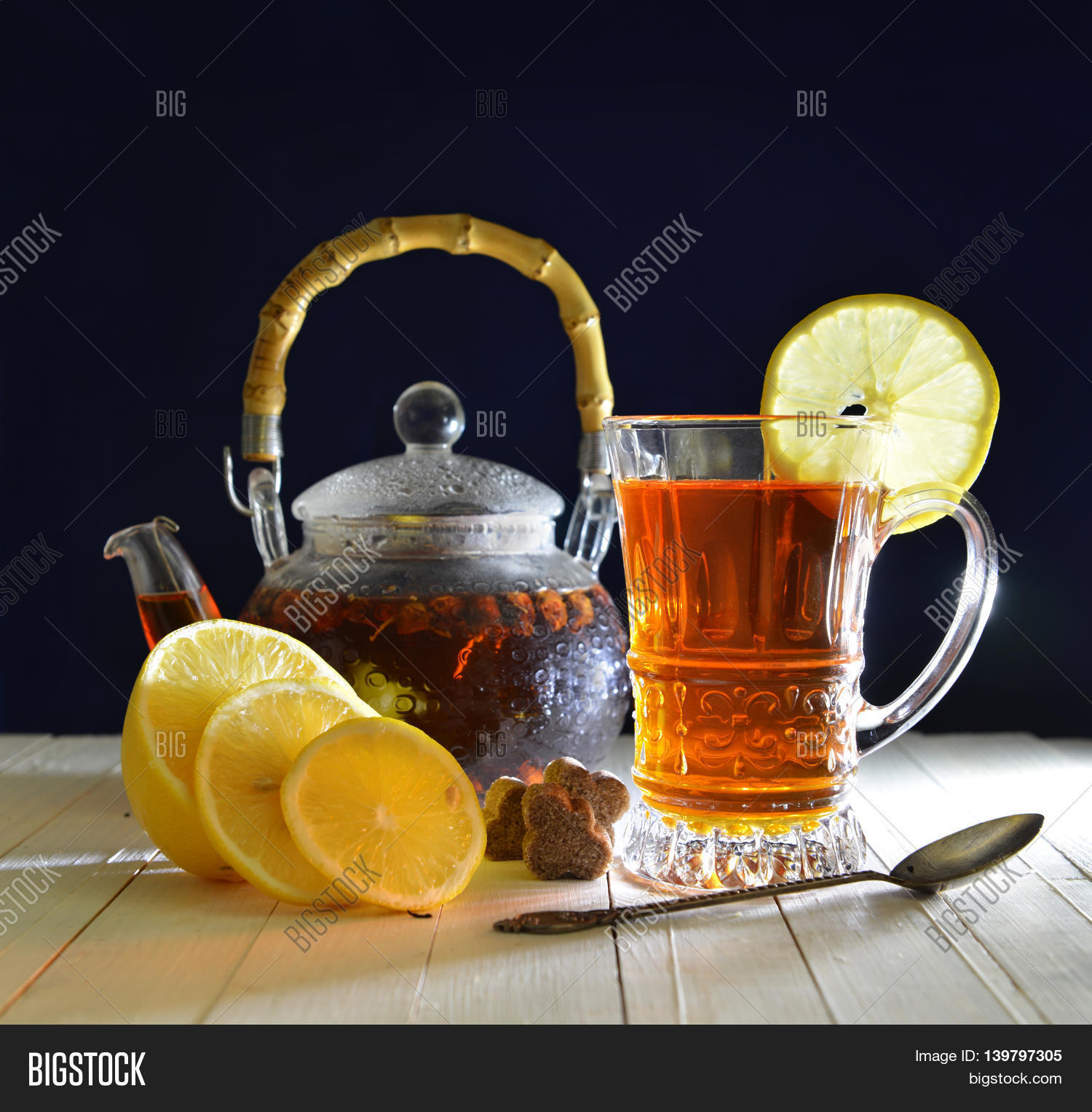 life with fresh tea in glass kitchenware, sliced lemons, brown
