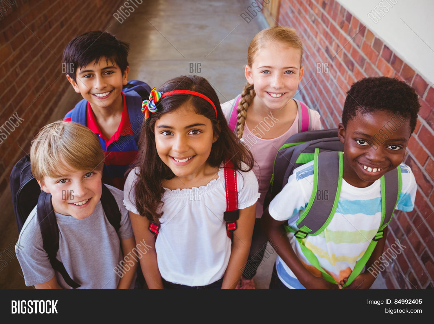 portrait of smiling little school kids in school corridor