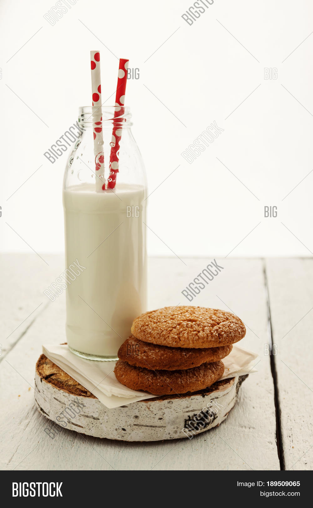 a stack of round shortbread cookies and a bottle of milk on a
